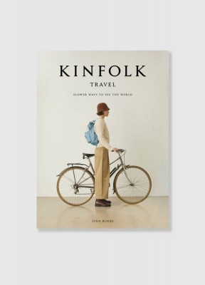 Coffee table book från Kinfolk boken heter travel, beiget  med svart text och en person som står bredvid en cykel