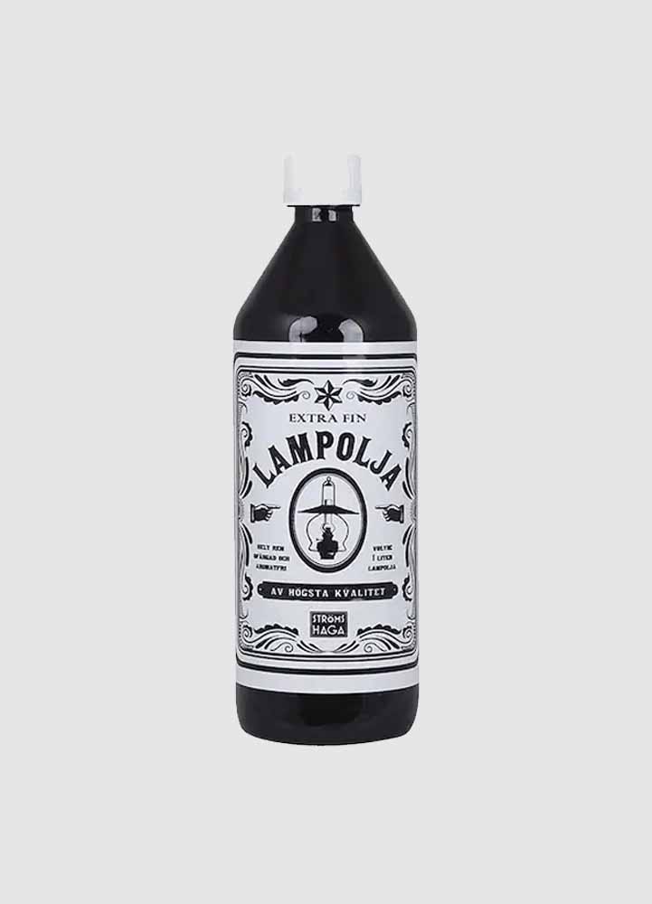Lampolja i en svart flaska med vit kork, med en stor vit etikett med svart text som säger extra fin lampolja av högsta kvalitet.
