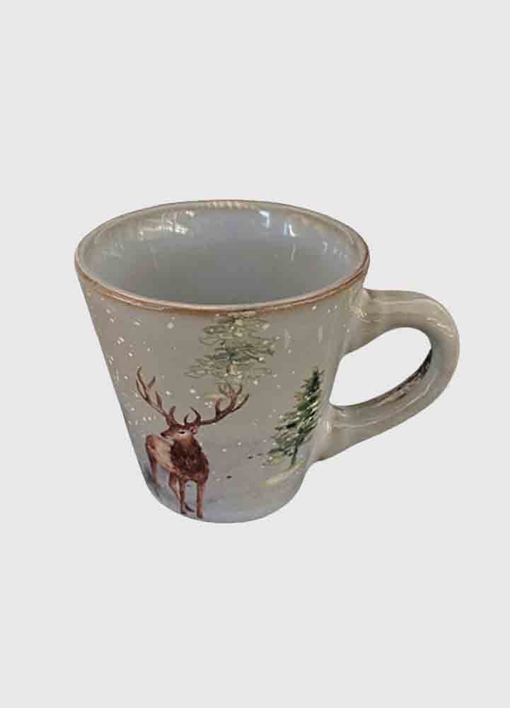 Julmugg i grå stengods med handtag som är sex centimeter hög med målat vintermotiv i form av en hjort bland snö och granar.

