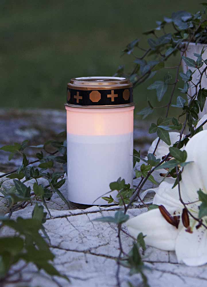 Elegant vitt gravljus med mjukt sken, 12 cm högt, drivs av 2 AA-batterier. Inbyggd timer för enkel inställning av ljusningstid. Perfekt för att hedra och minnas nära och kära.